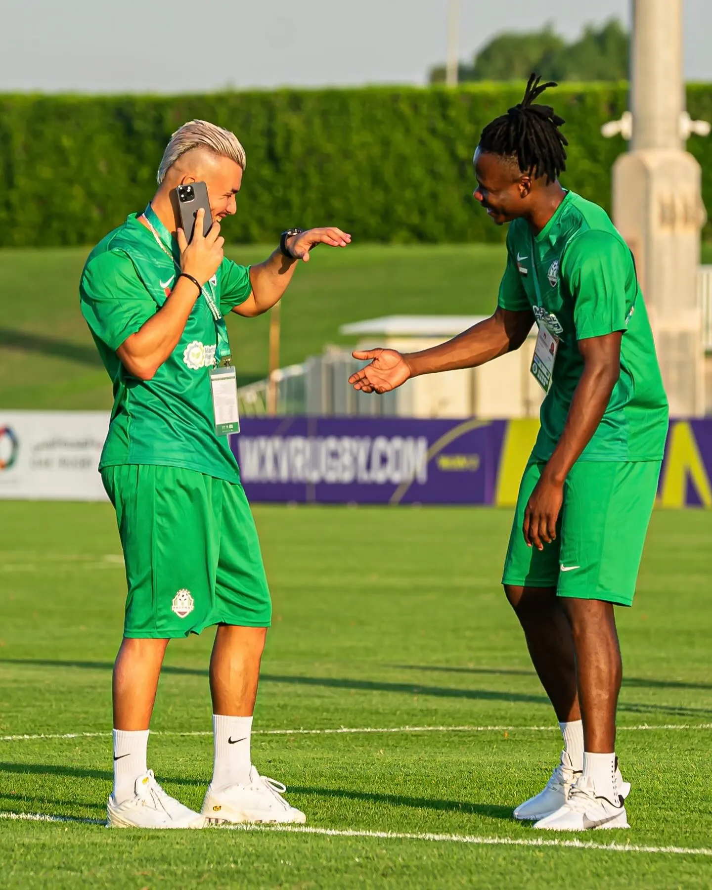 Two Madenat FC players laughing on the pitch